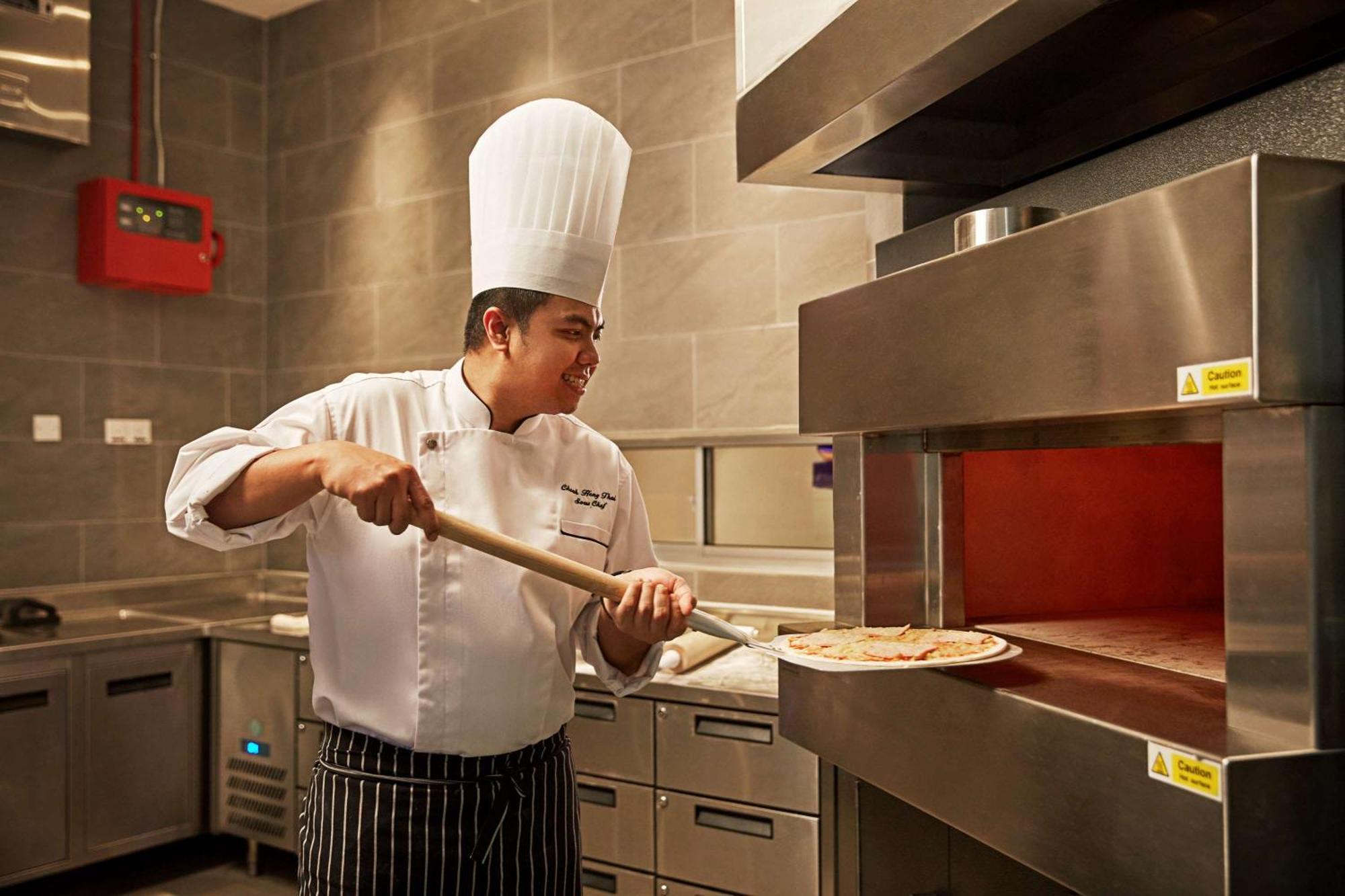 Hotel Doubletree By Hilton Melaka Malacca Esterno foto A pizzaiolo preparing a pizza